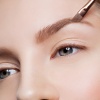 Die Augenbraue einer Frau wird natürlich geschminkt