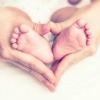 Hände umfassen Babyfüße