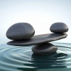Steine sind im Wasser übereinander gestapelt als Zeichen für Balance