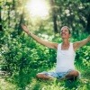 Frau meditiert bewusst im Wald