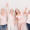 Frauen mit rosa T-Shirts und rosa Schleife als Zeichen für Brustkrebs
