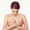 Eine Frau betrachtet ihre hängenden Brüste
