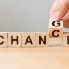 Das Wort Chance ist auf sechs Holzblöcken ausgeschrieben. Einer der Holzblöcke wird gerade umgedreht und man erkennt, dass auf der Rückseite der Buchstabe G ist, wodurch das Wort in den englischen Begriff change umgewandelt wird.
