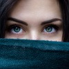 Frau mit sensibler Haut versteckt ihr Gesicht hinter einem Schal