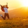 Frau macht einen Luftsprung im Sonnenuntergang