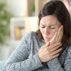 Eine Frau hat Schmerzen wegen einer Erkrankung im Mund