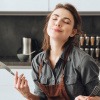 Frau genießt ihr Essen in der Küche