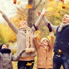 Familie im Herbst spielt mit Laub