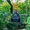 In einem Feng Shui Garten befindet sich eine Buddhastatue aus Stein