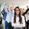 Hinter einer Frau in der Führungsrolle steht ein jubelndes Team