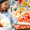 Frau kauft sich basische Lebensmittel am Markt