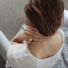 Frau mit Nackenschmerzen nach dem Schlafen