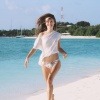 Eine Frau ohne Rasurbrand läuft im Bikini über den Strand