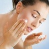 Eine Frau gibt zum Rasieren gegen Falten Rasierschaum auf ihr Gesicht