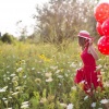 Eine Frau trägt rote Ballons