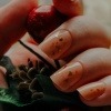 Hände mit Glass Nails halten eine Blume