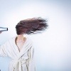 Eine Frau föhnt ihre Haare mit einem Föhn