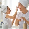 Frau und Mädchen bauen mit Kosmetik ihr Hautmikrobiom auf