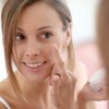 Eine Frau benutzt Hyaluronsäure Kosmetik