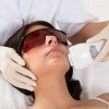 Frau die sich gerade eine Gesichtsbehandlung mit Ultraschall machen lässt