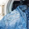 Jeans werden in Waschmaschine gegeben, um Jeans richtig zu waschen 