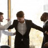 Ein Mann schlichtet zwischen zwei streitenden Arbeitskollegen