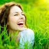 Eine lachende Frau liegt im Gras