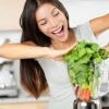 Eine Frau steckt Lebensmittel, die glücklich machen, in einen Mixer