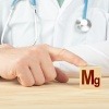 Arzt hält Würfel mit Mg (Magnesium)