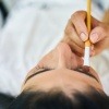 Eine Frau wird mit Make-up geschminkt