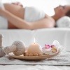 Massageambiente mit schwangerer Frau im Hintergrund