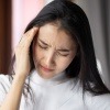 Frau mit einseitigen Kopfschmerzen oder Migräne
