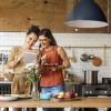 Nachhaltig zu kochen bedeutet, sich wie die Frau in diesem Bild an saisonalen und regionalen Lebensmitteln zu orientieren, die vor ihr auf dem Küchentresen liegen.