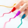 Finger mit Nagellack in Regenbogenfarben hinterlassen auf einem Blatt Papier die Farbe