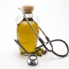 Olivenölflasche mit Stethoskop in Herzform gelegt
