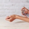 Eine Frau sprüht sich Parfum auf ihr Handgelenk