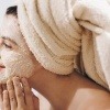 Frau mit Peeling im Gesicht gegen Hautunreinheiten