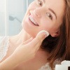 Eine Frau reinigt ihr Gesicht mit Mizellenwasser