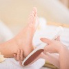 Fuß wird von Kosmetikerin behandelt