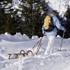 Eine Frau geht mit einer Rodel durch den Schnee