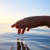 Ruhige Kreise im Wasser werden durch einen Finger gezogen