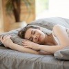 Eine Frau schläft ruhig in ihrem Bett