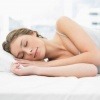 Frau schläft entspannt, weil keine Störfaktoren im Schlafzimmer sind