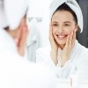 Eine Frau betrachtet ihre Zähne im Spiegel