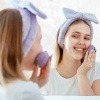 Frau wäscht Gesicht mit Seife
