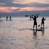 Eine Gruppe von Menschen macht die Trendsportart Stand Up Paddling