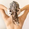 Eine Frau wäscht ihre Haare, täglich oder weniger oft