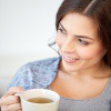 Eine Frau hält eine Tasse Tee in der Hand und fragt sich, ob Tee trinken gesund ist