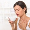 Eine Frau hat Halsschmerzen durch trockene Atemwege