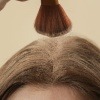 Eine Frau gibt selber gemachtes Trockenshampoo auf die Haare